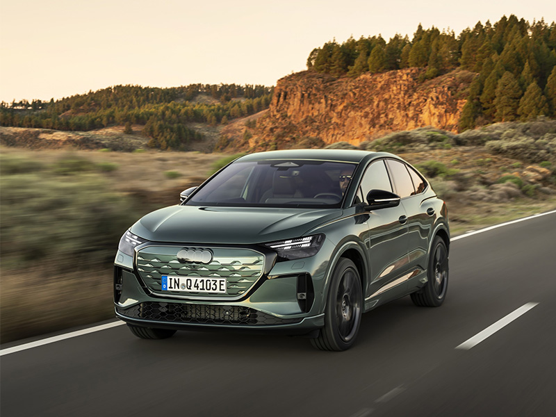green new audi q4 e-tron driving on road